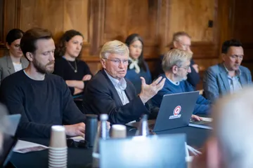A senior academic making a point across the table during the Yarnton Manor retreat.
