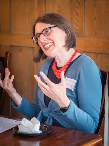 A participant speaking animatedly at the table during the retreat discussion.
