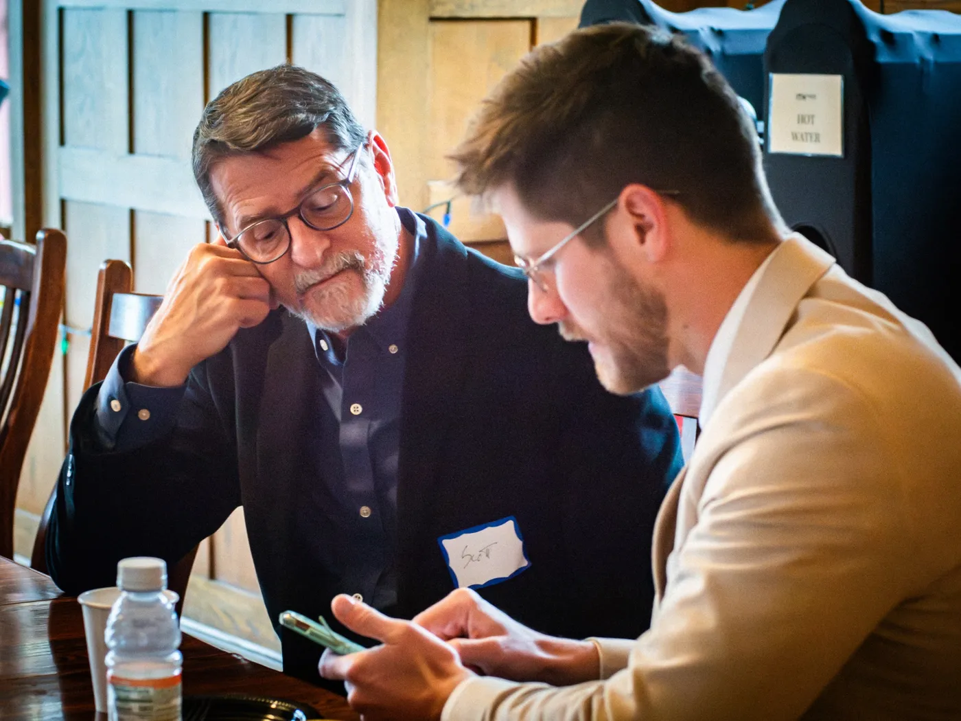 Two retreat participants comparing notes together over the table.
