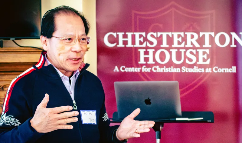 K. K. Yeo speaking to scholars in front of a Chesterton House banner at Cornell University.